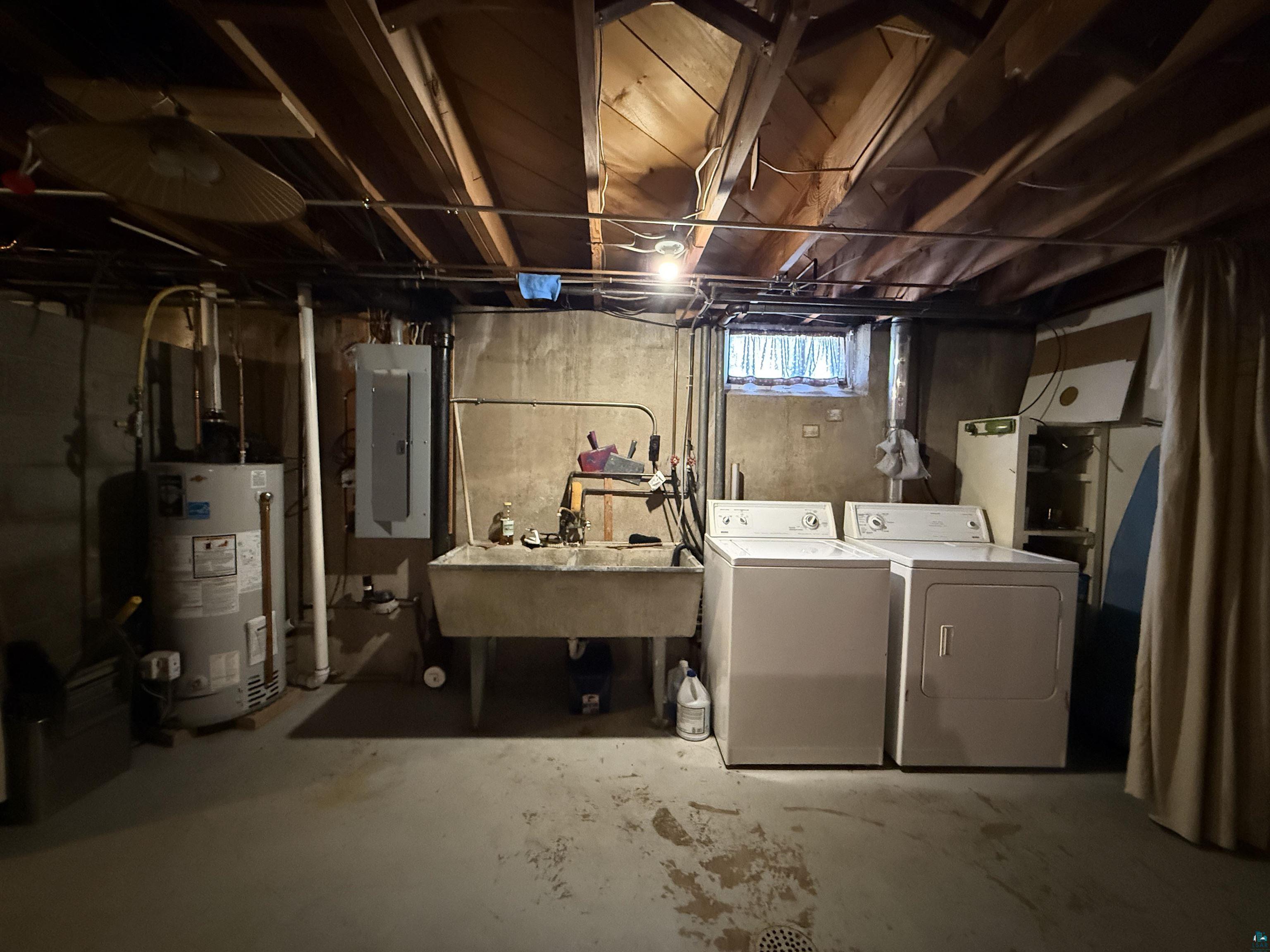 607 3rd Street Northeast Chisholm, MN 55719 - Photo 24 of 32 Basement utility area featuring a water heater, electrical panel, and a concrete utility sink