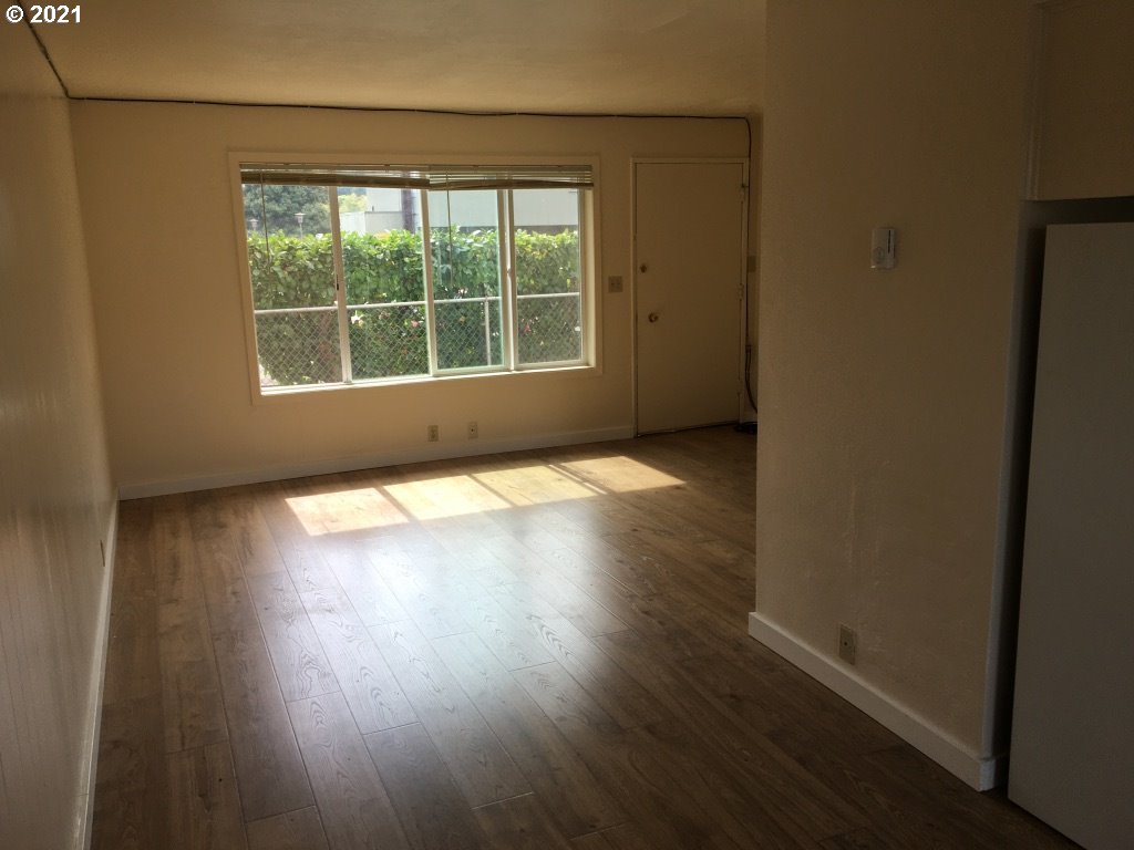 310 Mill Street Springfield, OR 97477 - Photo 7 of 9 an empty room with wooden floor and windows