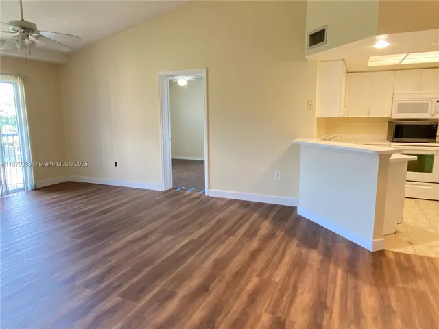 a view of a kitchen with wooden floor and a sink