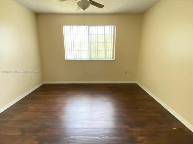 an empty room with wooden floor and a window