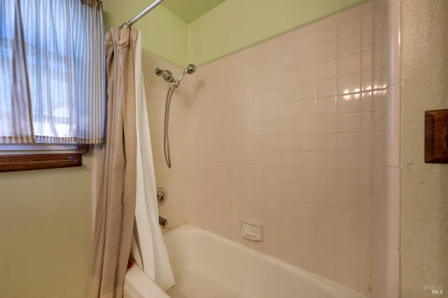 a bathroom with a shower curtain and a shower
