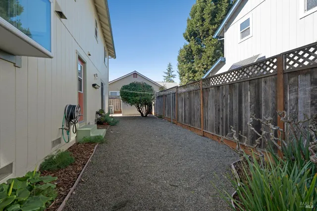 a view of backyard with potted plants and wooden fence
