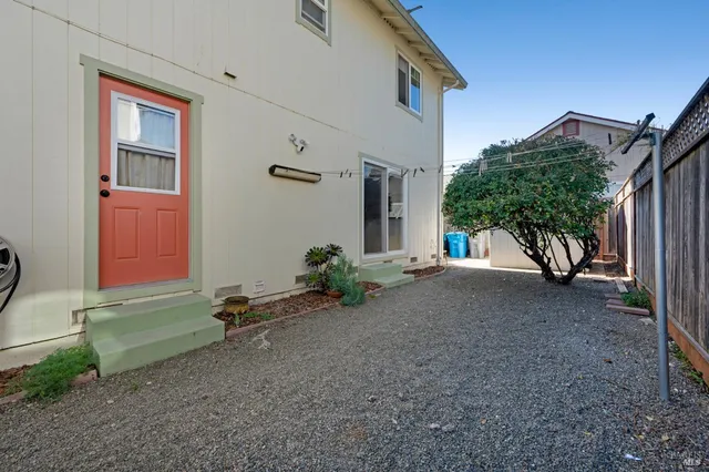 a view of a house with backyard and a tree