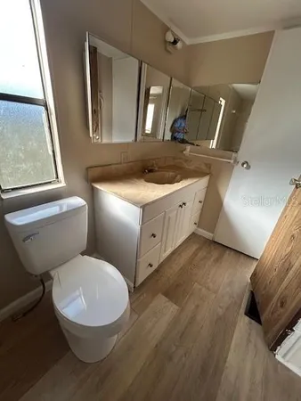 a bathroom with a granite countertop toilet sink and mirror