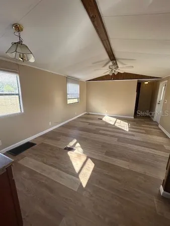 a view of empty room with wooden floor