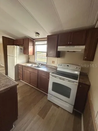 a kitchen with a stove sink and cabinets