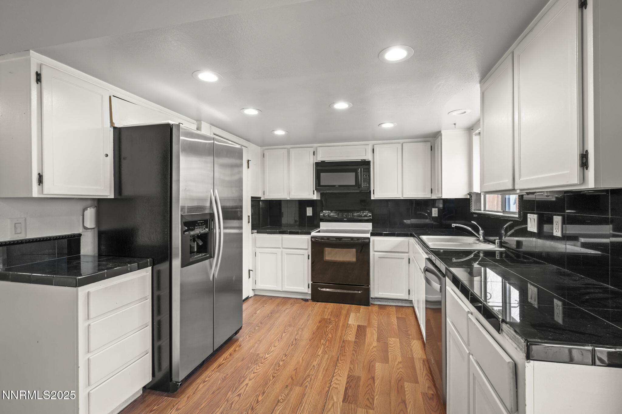 1720 Peavine Road Reno, NV 89503 - Photo 11 of 24 a kitchen with a refrigerator a sink a stove a microwave and cabinets
