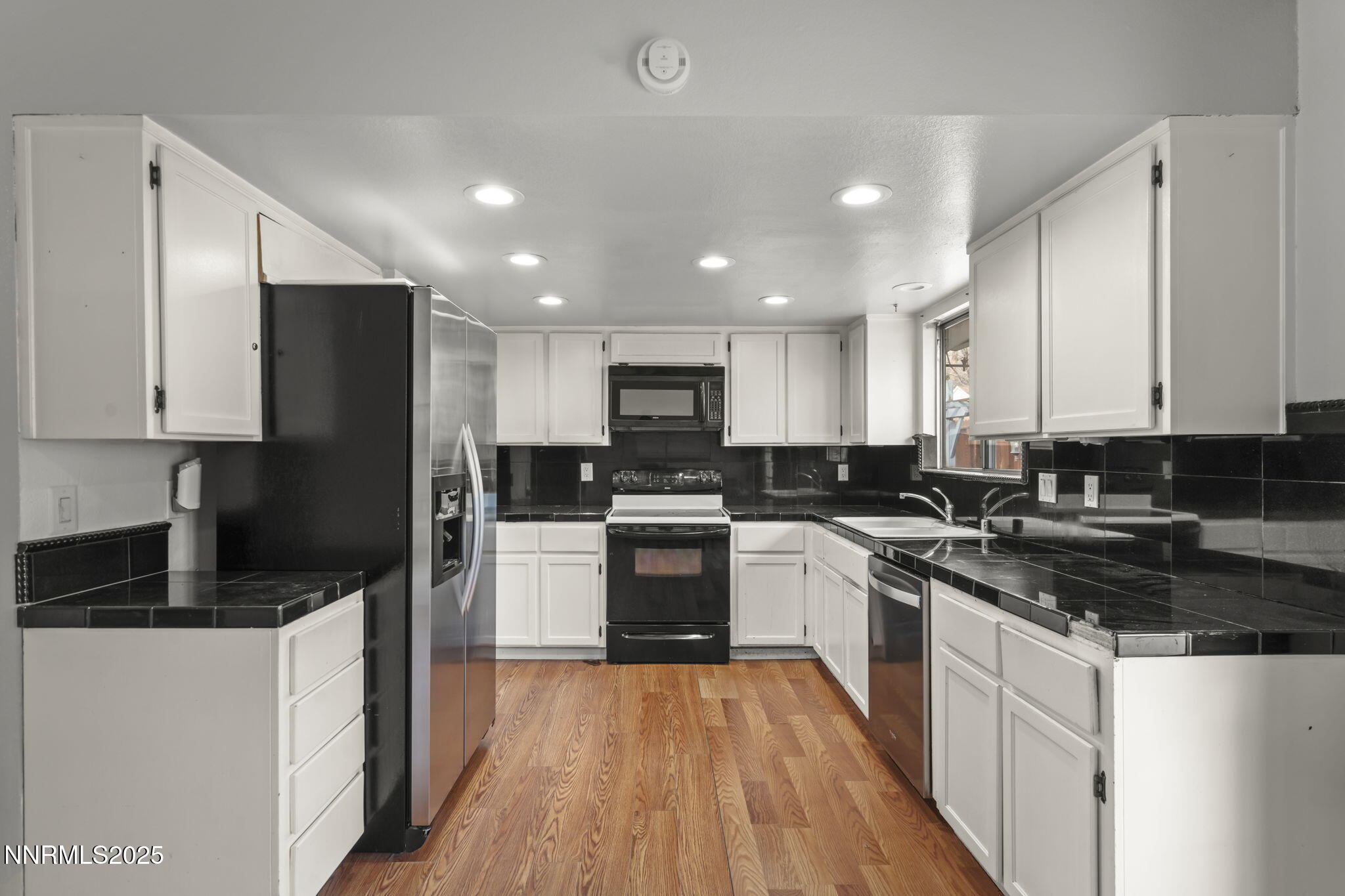 1720 Peavine Road Reno, NV 89503 - Photo 12 of 24 a kitchen with white cabinets and stainless steel appliances