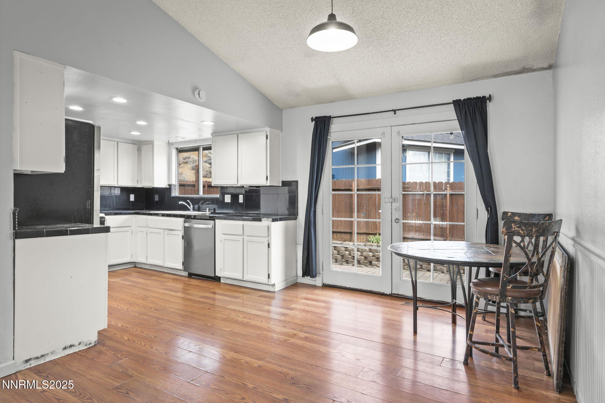 1720 Peavine Road Reno, NV 89503 - Photo 10 of 24 a kitchen with stainless steel appliances wooden floors and white cabinets