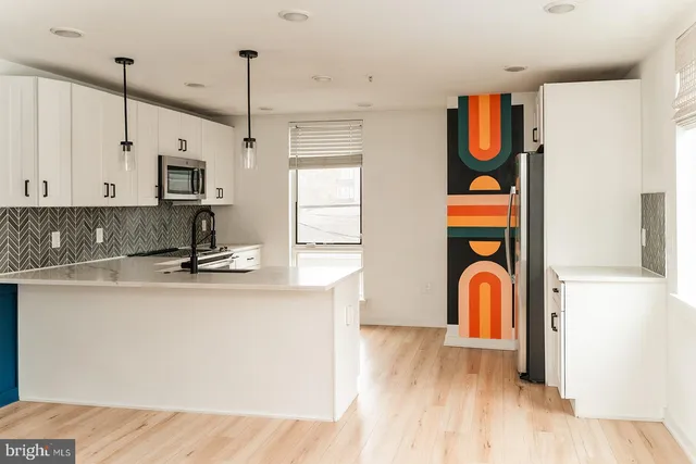 a kitchen with stainless steel appliances granite countertop a sink a stove and wooden floor