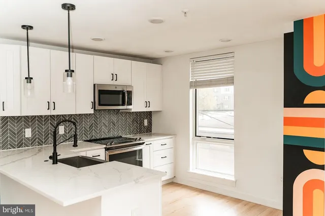 a kitchen with stainless steel appliances granite countertop a sink and a stove