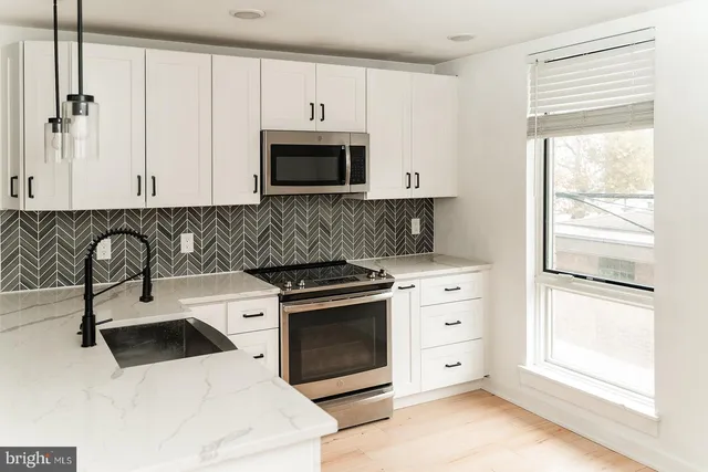 a kitchen with white cabinets and a stove