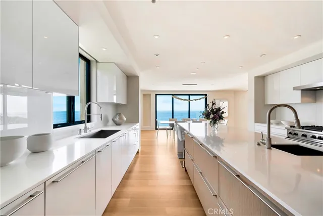 a kitchen with a sink a counter top space stainless steel appliances a large window and cabinets
