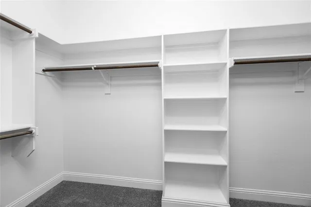 a view of walk in closet with empty racks