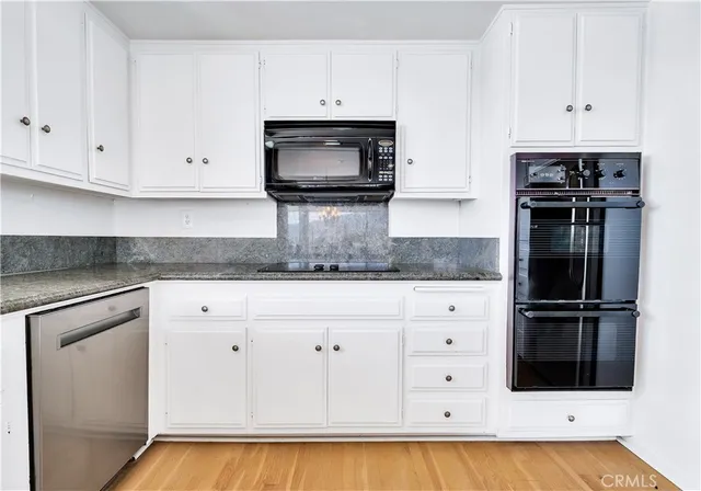a bathroom with a sink double vanity granite tub shower and a mirror
