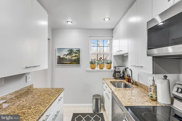 a kitchen with stainless steel appliances granite countertop a refrigerator and a stove top oven