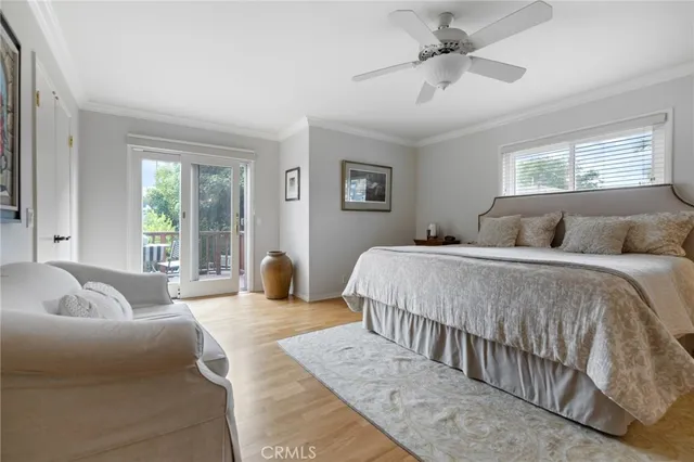 a bedroom with a large bed couch and two windows
