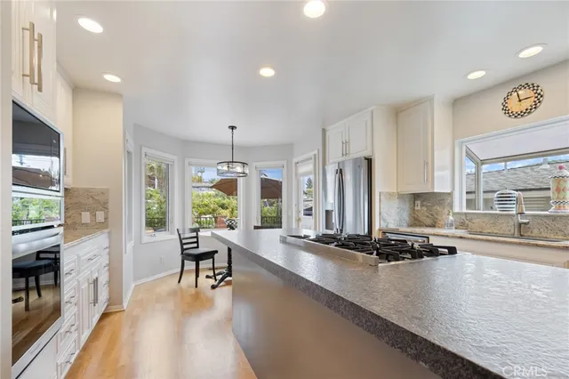 a dining room with stainless steel appliances granite countertop a stove and a refrigerator