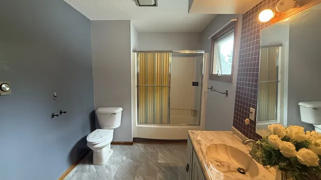 a bathroom with a toilet sink and shower