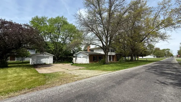 a front view of a house with a yard and trees