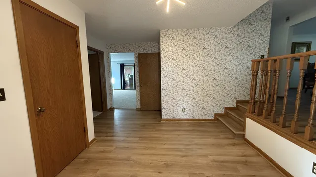 a view of a hallway with wooden floor and staircase
