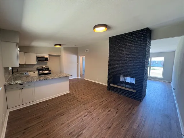 a view of kitchen view with wooden floor and fire place