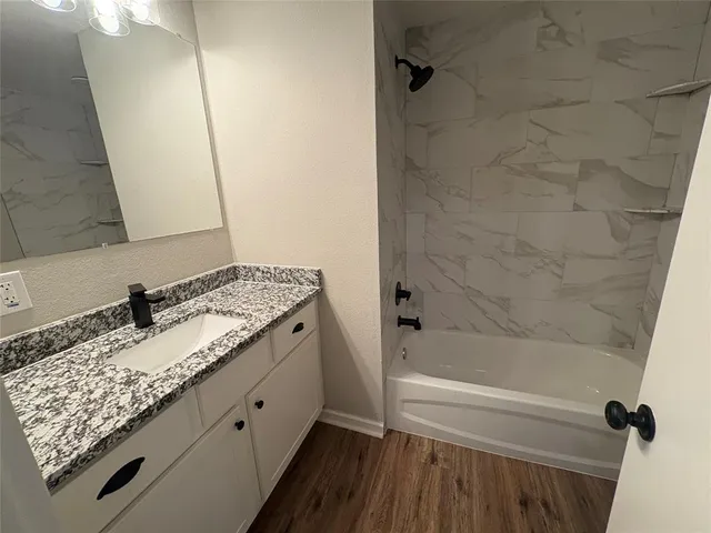 a bathroom with a granite countertop sink toilet and shower