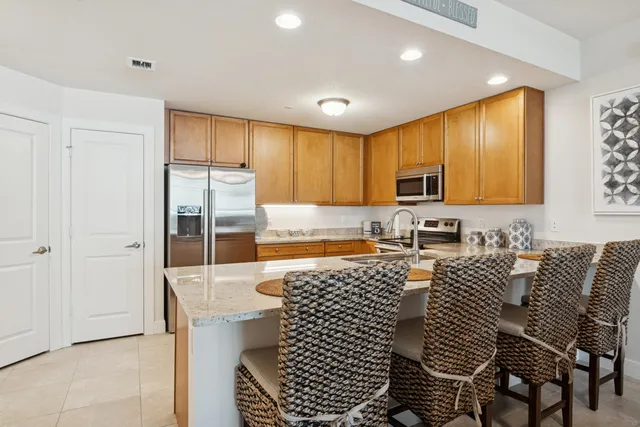 a kitchen with granite countertop a refrigerator and cabinets