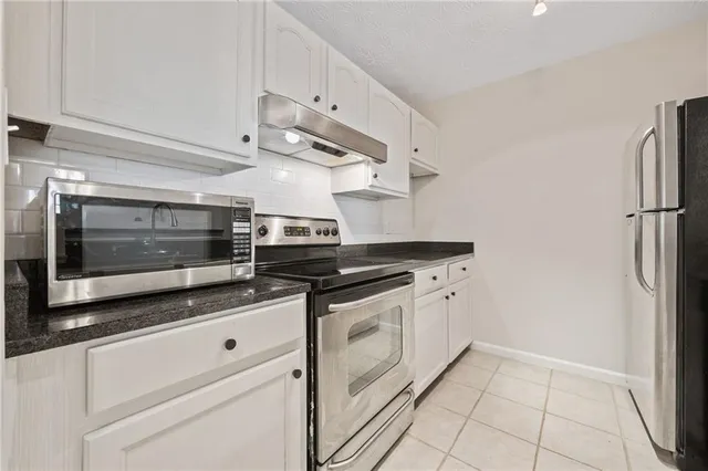 a kitchen with stainless steel appliances white cabinets and a fireplace