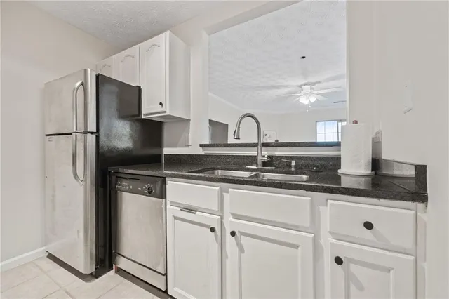 a kitchen with granite countertop white cabinets and stainless steel appliances