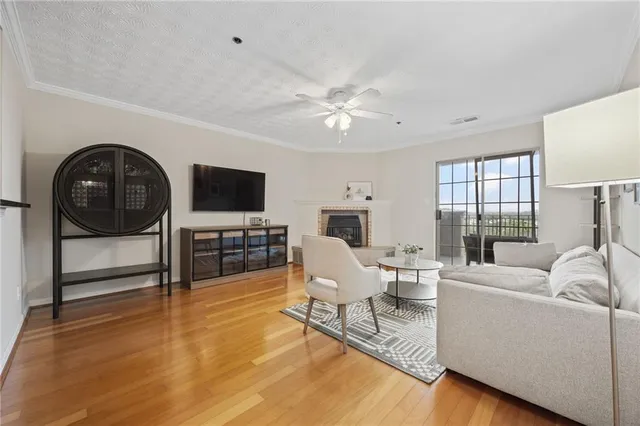 a living room with furniture a flat screen tv and a floor to ceiling window