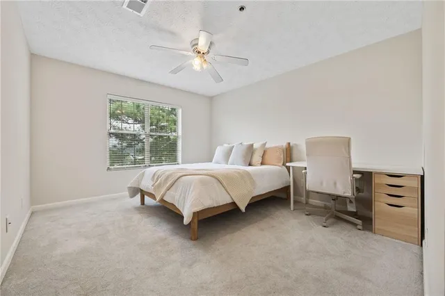 a spacious bedroom with a bed and a chair