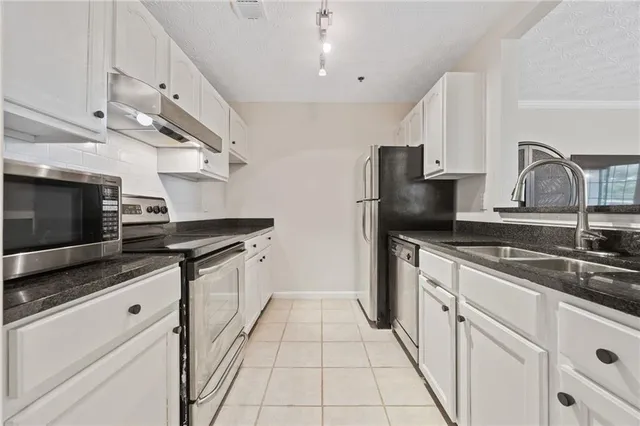 a kitchen with stainless steel appliances granite countertop a sink and a stove