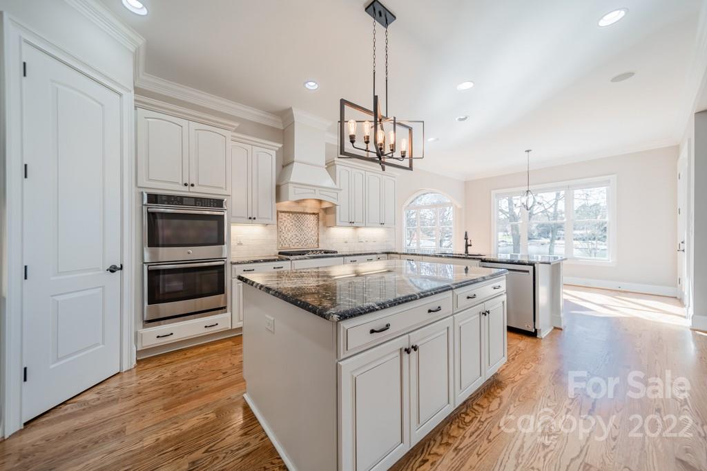 144 Greyfriars Road Mooresville, NC 28117 - Photo 14 of 43 a kitchen with stainless steel appliances granite countertop a kitchen island a stove and a wooden floors