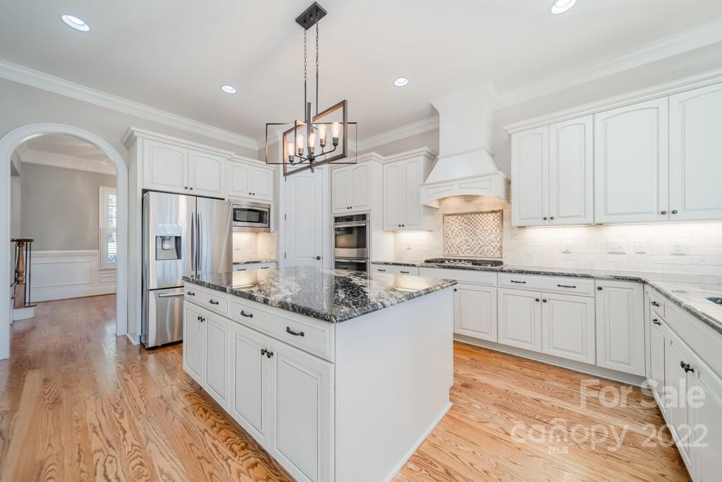 144 Greyfriars Road Mooresville, NC 28117 - Photo 15 of 43 a large kitchen with kitchen island white cabinets and stainless steel appliances