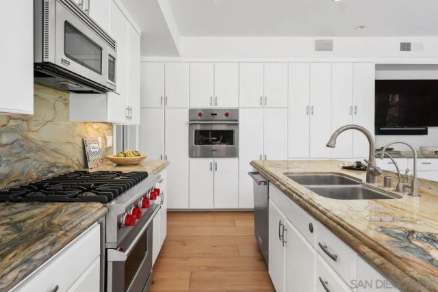 a kitchen with granite countertop a sink stove and cabinets