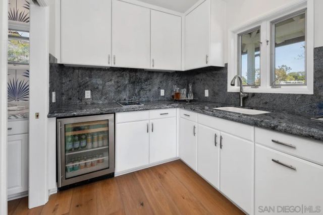 a kitchen with granite countertop white cabinets and a stove