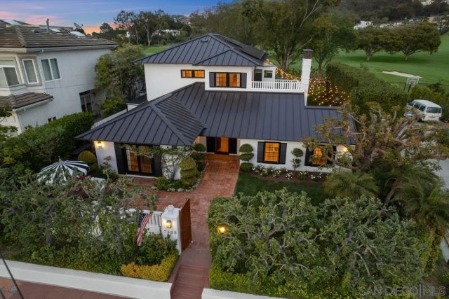 an aerial view of house with yard and trees in the background