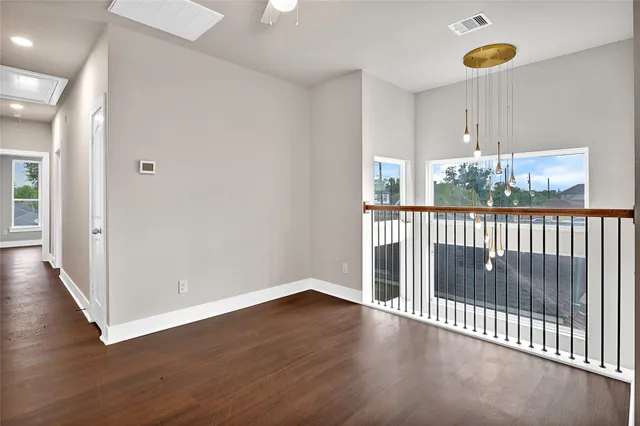 a view of a room with wooden floor windows and a chandelier