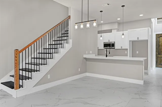 a view of kitchen with kitchen island stainless steel appliances sink stove and cabinets