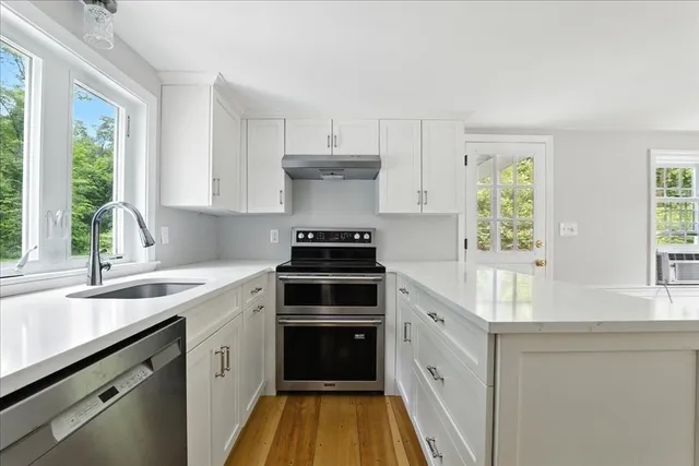 a kitchen with stainless steel appliances kitchen island granite countertop a refrigerator and a sink