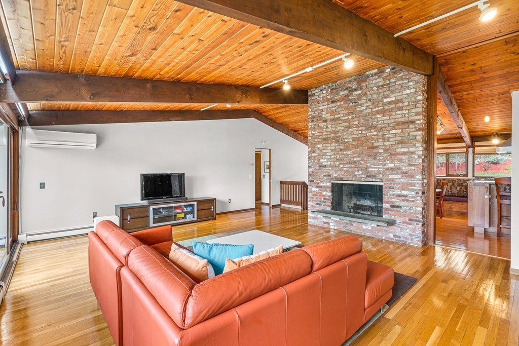 65 Spring Grove Road Andover, MA 01810 - Photo 8 of 41 a living room with furniture a fireplace and a flat screen tv