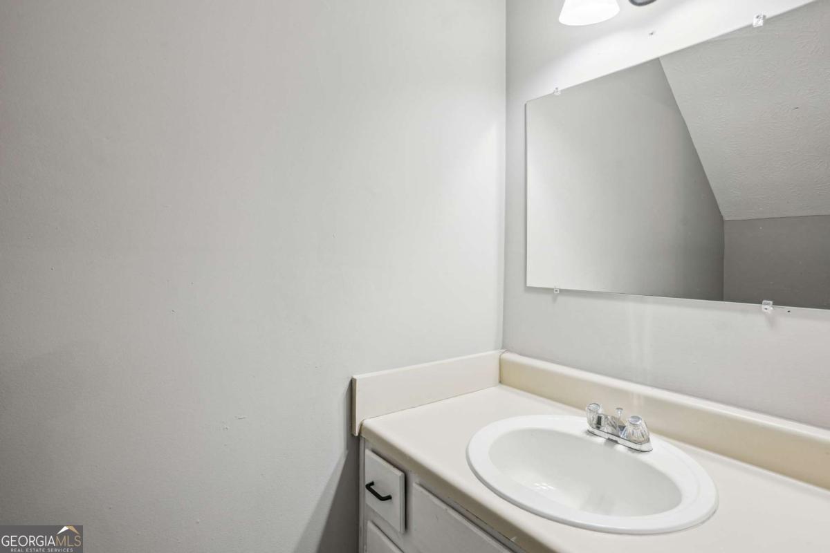 2049 Charter Lane Lithonia, GA 30058 - Photo 20 of 25 a bathroom with a sink a vanity and a mirror