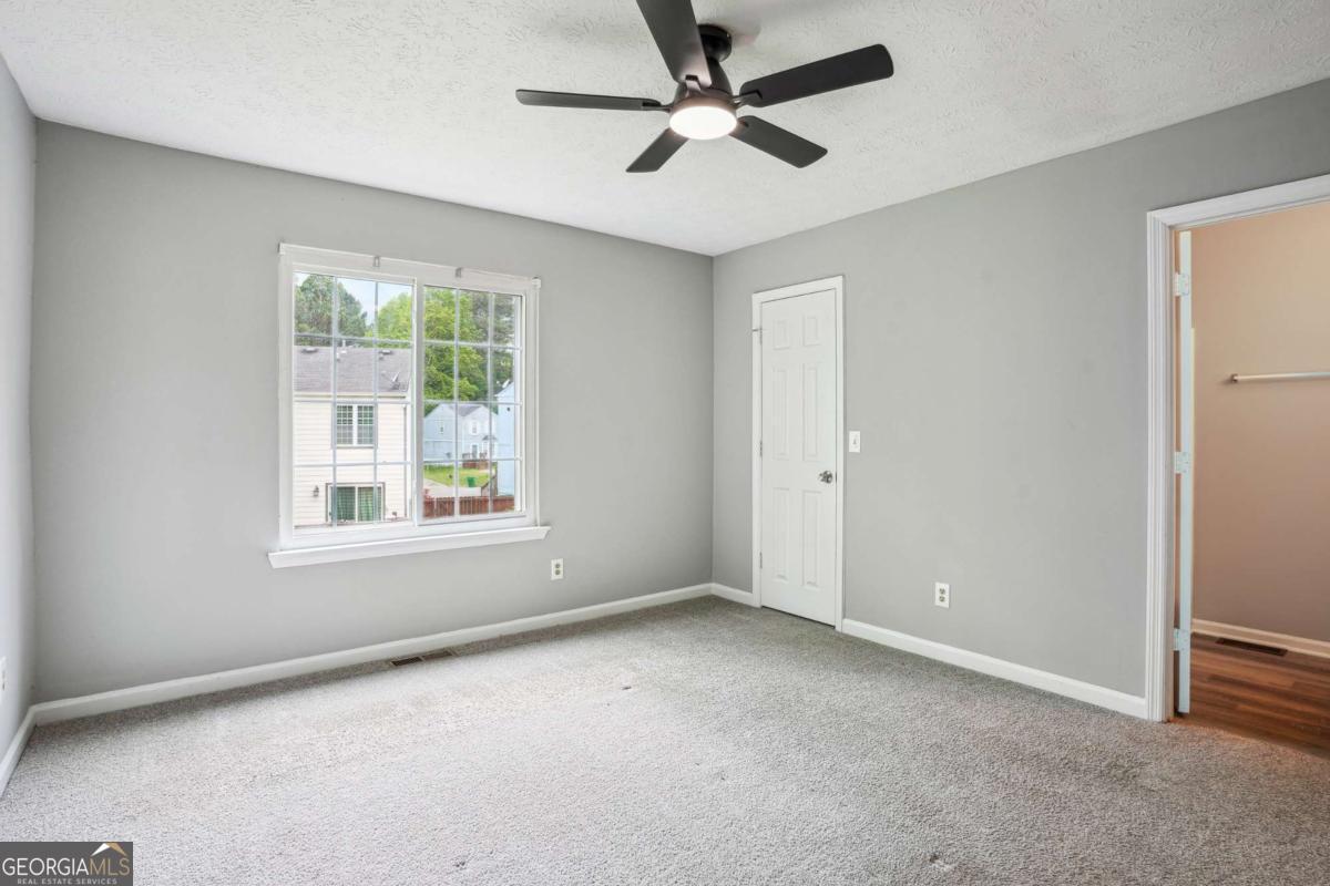 2049 Charter Lane Lithonia, GA 30058 - Photo 10 of 25 an empty room with a window and a fan
