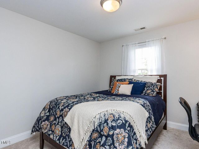 a bed sitting in a bedroom next to a window