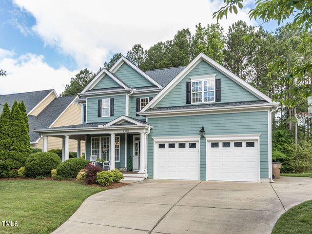 a front view of a house with a yard and potted plants