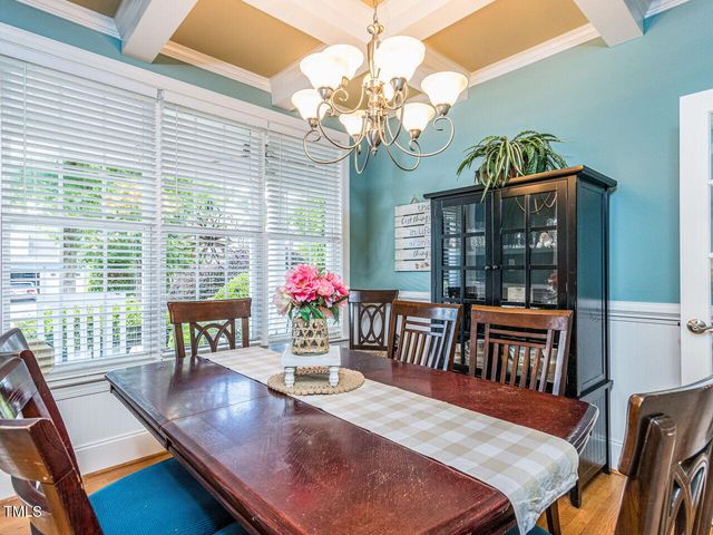 a dining room with furniture a chandelier and wooden floor