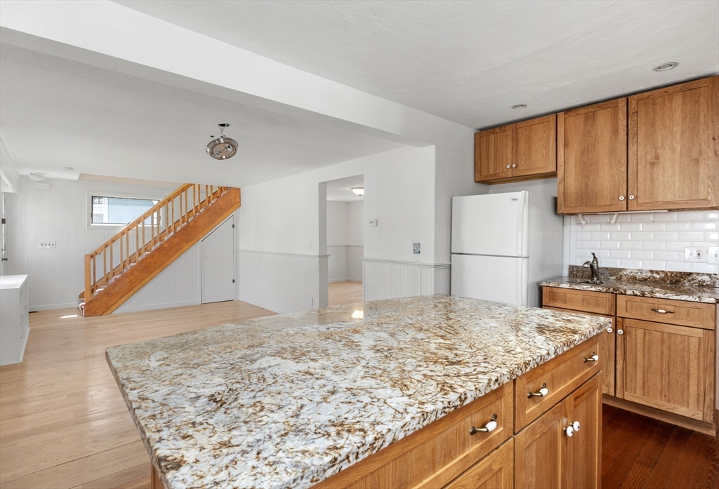7 Grove Street Wareham, MA 02558 - Photo 9 of 41 a kitchen with kitchen island sink refrigerator and cabinets