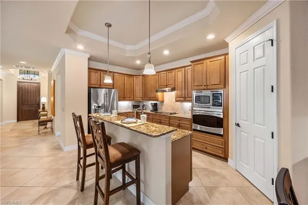 a kitchen with stainless steel appliances granite countertop a stove a refrigerator a oven a sink with a dining table and chairs
