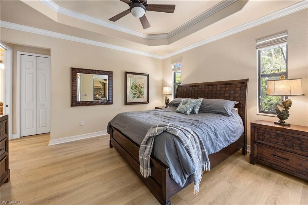 9234 Veneto Place Naples, FL 34113 - Photo 18 of 38 a bedroom with a bed lamps and window